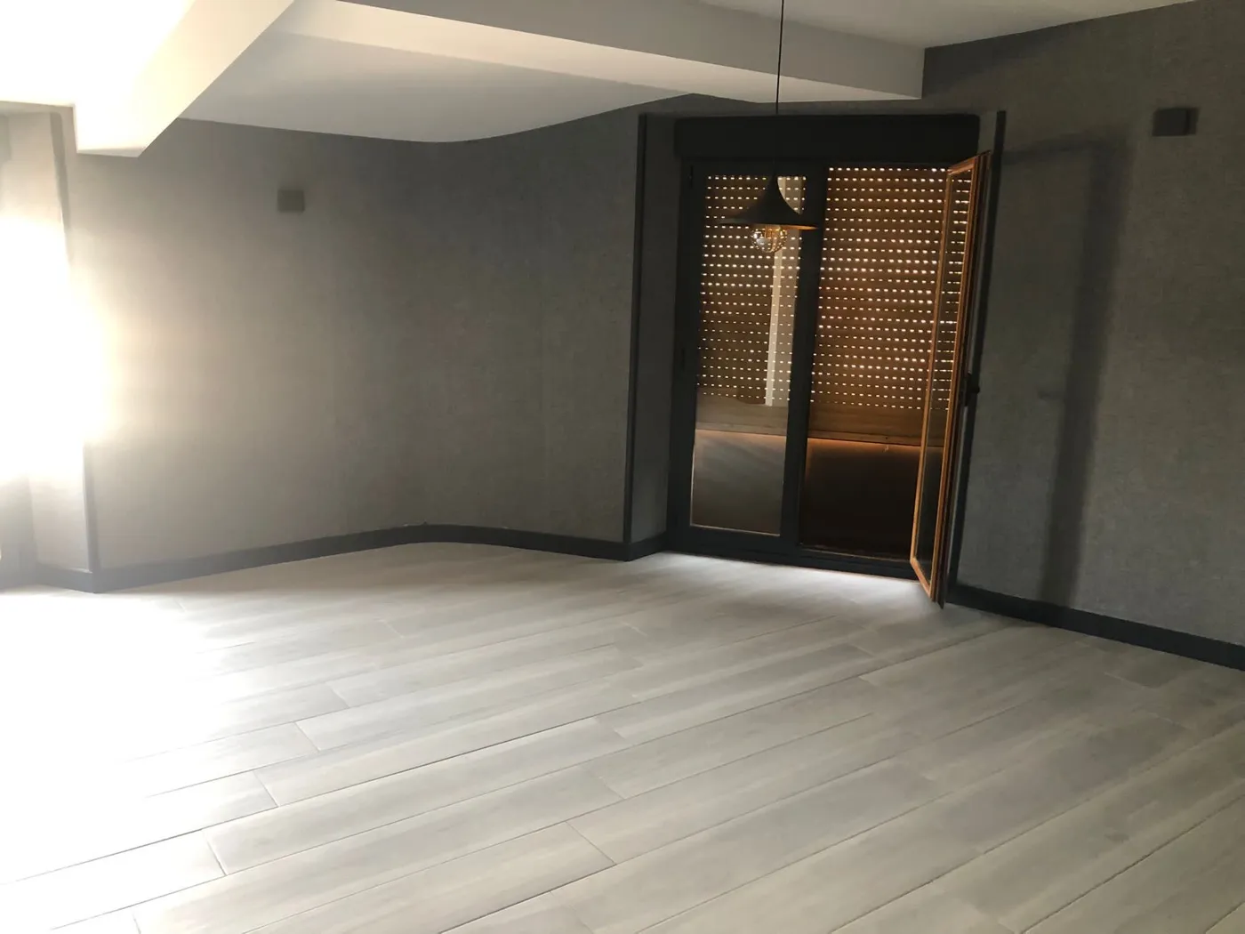 Salón con puerta corredera de diseño y suelo claro