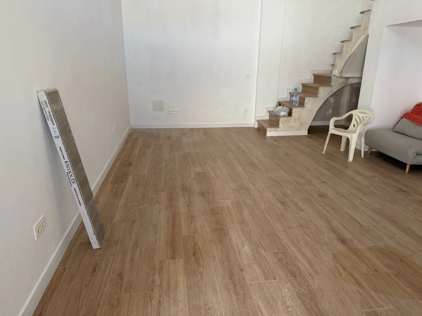 Salón en reforma integral con suelo nuevo y escalera